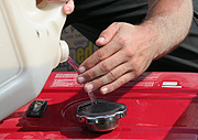 Industry, petroleum, petrol, generator, generators, hand, hands, bottle, bottles, plastic, plastic bottle, plastic bottles, cap, caps, lid, lids.