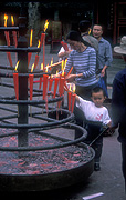 Asia, china, sichuan, sichuan province, province, provinces, baoguo, baoguo monastery, monastery, monasteries, incense, candle, candles, chinese, woman, women, people, child, children, mother, mothers, parent, parents, parenting, parenthood, religion, religious building, religious buildings, architecture, emei, mount emei, mt emei, flame, flames.