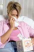 YOUNG WOMAN BLOWING HER NOSE